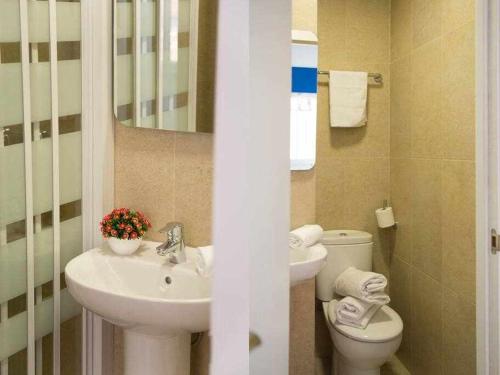 łazienka z umywalką, toaletą i lustrem w obiekcie Comodo y agradable estudio en Madrid centro A6 w Madrycie