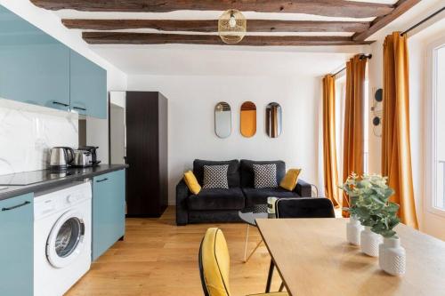 cocina y sala de estar con mesa y sofá en Grands Boulevards 22 : Appartement Cosy 1BR-4P, en París