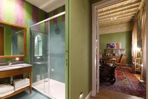een badkamer met een glazen douche en een wastafel bij Prestige Boutique Aparthotel - Montenapoleone in Milaan