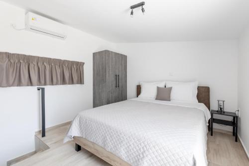 um quarto com uma grande cama branca e uma janela em Pagani Green - Luxury Maisonette B3 em Kalamata