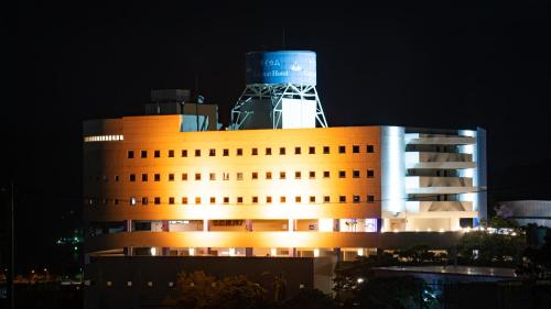 um edifício com uma torre em cima à noite em Rycom Crystal Hotel em Okinawa City