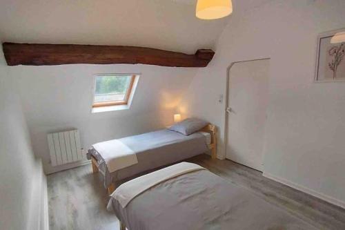 a bedroom with two beds and a window at gîte Maison entière 6 personnes in Saint-Julien-de-Chédon