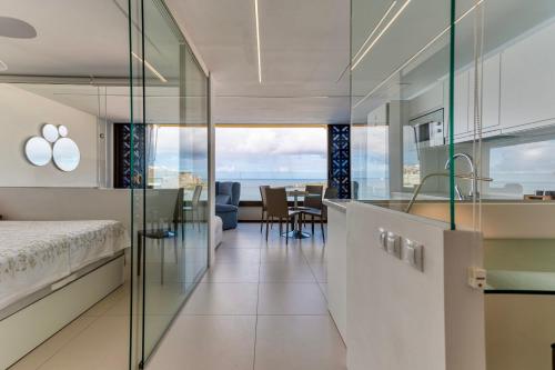 a bedroom with a bed and a dining room at Brand New - Ocean Views - Sunset Facing in Patalavaca