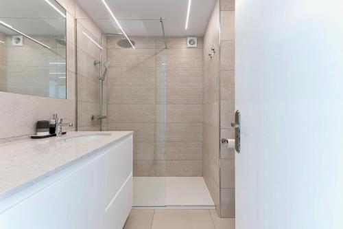 een badkamer met een douche en een witte wastafel bij Brand New - Ocean Views - Sunset Facing in Patalavaca