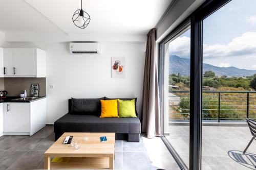 a living room with a couch and a balcony at Pagani Green - Luxury Maisonette B3 in Kalamata