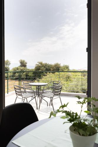 a patio with chairs and a table on a balcony at Pagani Green - Luxury Maisonette B3 in Kalamata
