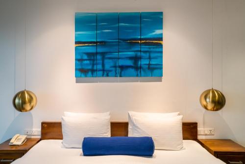 a bedroom with a bed and a painting on the wall at Agnus Unawatuna in Unawatuna
