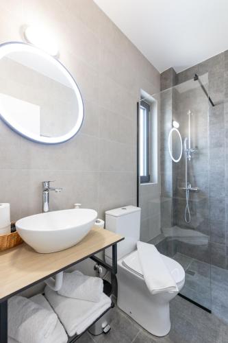 a bathroom with a sink and a toilet and a mirror at Pagani Green - Luxury Maisonette B3 in Kalamata