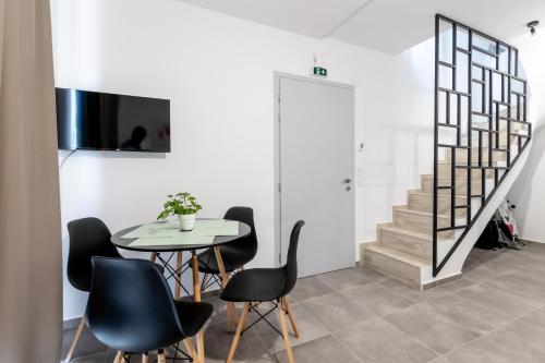 a dining room with a table and chairs and a staircase at Pagani Green - Luxury Maisonette B3 in Kalamata
