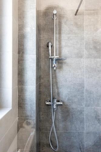 a shower with a shower head in a bathroom at Pagani Green - Luxury Maisonette B3 in Kalamata