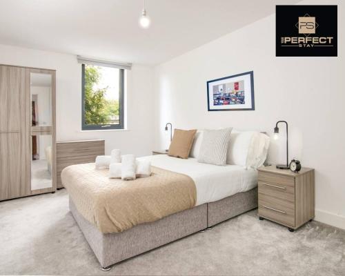 a white bedroom with a large bed and a window at Luxe Modern Apartment By Your Perfect Stay Short Lets Birmingham in Birmingham