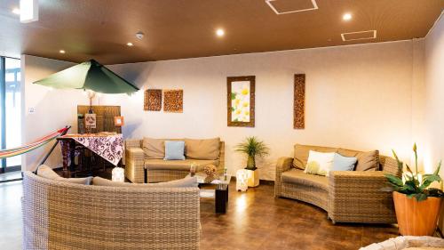 ein Wohnzimmer mit 2 Sofas und einem Tisch in der Unterkunft Rycom Crystal Hotel in Okinawa