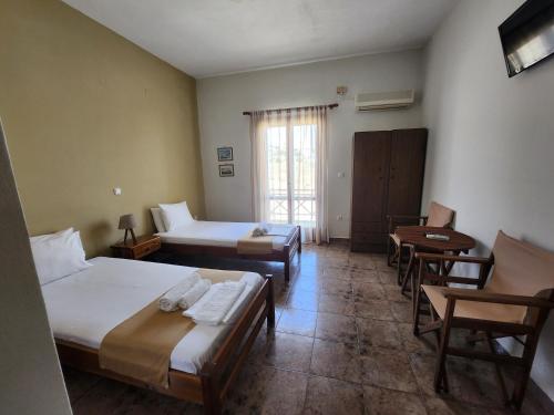 a room with two beds and a table and chairs at Theodorou in Azolimnos Syros