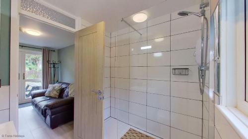 a bathroom with a shower with a glass door at 34 Strawberry Hill, Tolroy Manor in Hayle