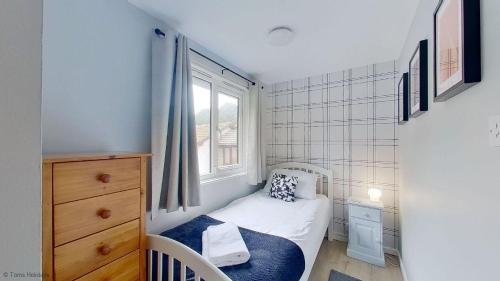 a small bedroom with a small bed and a window at 34 Strawberry Hill, Tolroy Manor in Hayle