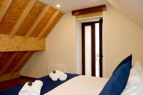 a bedroom with a bed with towels on it at Cabo do Mar Apart.- Baía Beach in Espinho