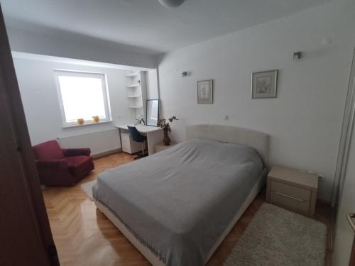 een slaapkamer met een bed, een bureau en een raam bij Maja Apartment in Skopje