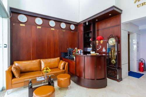 a lobby with a couch and clocks on the wall at La Serena Hotel & Apartment in Ho Chi Minh City