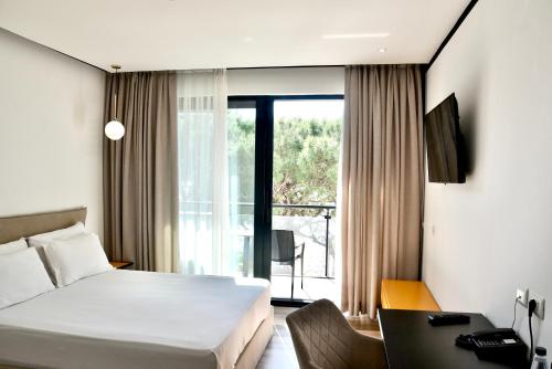 a hotel room with a bed and a large window at Royal G Max in Golem
