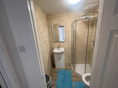 a bathroom with a shower and a sink and a toilet at Corby Guest House in Corby