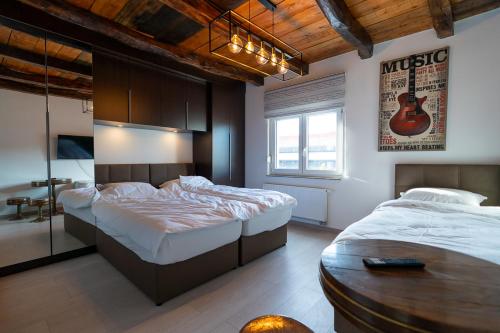 a bedroom with two beds and a guitar on the wall at Arena Rooms Zagreb in Zagreb