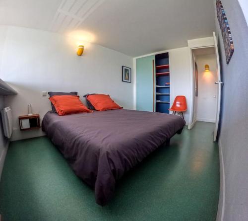 una camera da letto con un grande letto con cuscini arancioni di Le Corbusier Expérience a Firminy