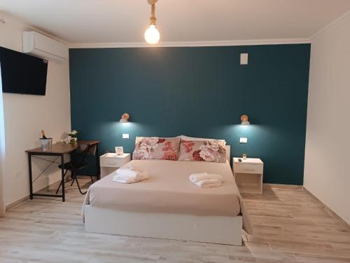 a bedroom with a white bed and a blue wall at La Casa Di Lucia in San Vito Chietino