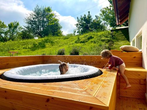 two children playing in a jacuzzi in a hot tub at Bohemian Eco lodge át lake Balaton in Kisapáti