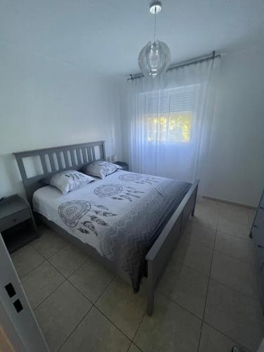 - une chambre avec un lit, une fenêtre et une lumière dans l'établissement Superbe 3 pièces épurée de 65 m2, refait à Neuf, dans residence calme, climatisé, place de parking privée, à 800 m de la plage, à Antibes