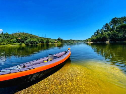an orange boat is sitting on a river at Quinta Alma Verde in Póvoa das Quartas