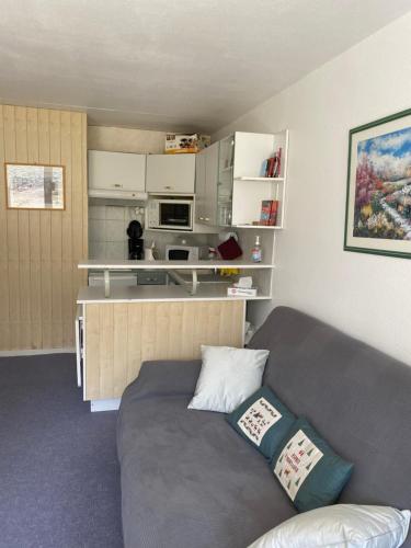 un salon avec un canapé et une cuisine dans l'établissement Studio 30m2 pour 4 pers La Mongie avec canape-lit et lit superposé, à La Mongie