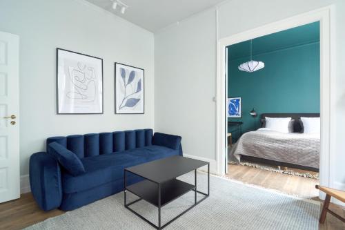 a living room with a blue couch and a bed at Perfect for Friends & Families 2 Bedroom Apartment in CPH in Copenhagen