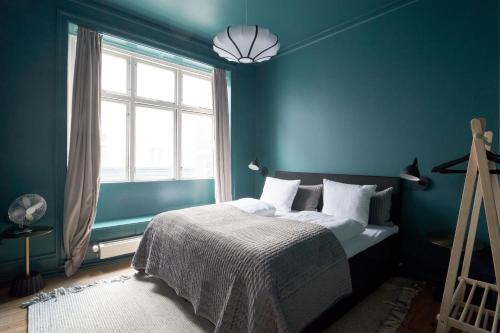a blue bedroom with a bed and a window at Perfect for Friends & Families 2 Bedroom Apartment in CPH in Copenhagen