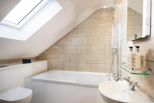 een badkamer met een wit bad en een wastafel bij The Granary at Rothley East Shield in Longwitton