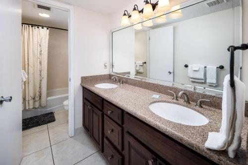 La salle de bains est pourvue de 2 lavabos et d'un grand miroir. dans l'établissement Nautilus 1501 - Gulf Front 2 Bedroom - 5th Floor - Huge Wrap Around Balcony, à Fort Walton Beach