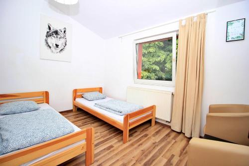 een slaapkamer met 2 bedden en een raam bij Hostel Cinnamon in Krakau
