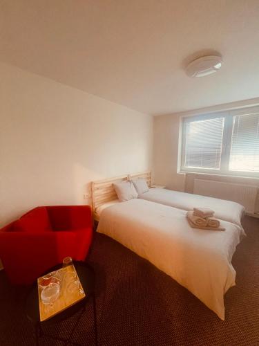 una camera con letto e sedia rossa di Pokoje na Hlavní Vřesina a Vřesina