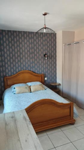 - une chambre avec un lit en bois et une couverture bleue dans l'établissement Maison campagne, à Roz-Landrieux