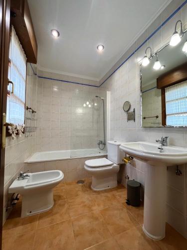 a bathroom with a toilet and a sink and a tub at Chalet adosado en Ribadesella in Ribadesella