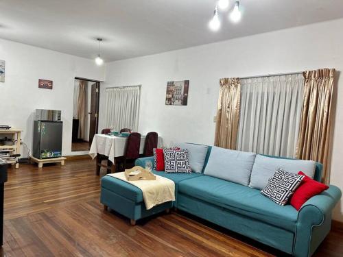 a living room with a blue couch and a table at Apartamento cómodo y céntrico in Sucre