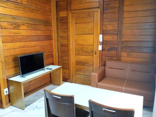 貝洛奧里藏特的住宿－VIA SPE - Pousada，客房设有书桌、电视、桌子和椅子。