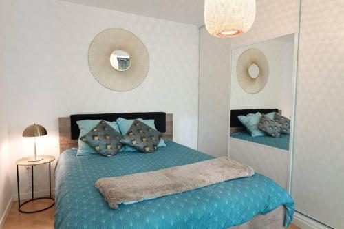 a bedroom with a blue bed with a mirror at Au Vasco - Self Check-In, Private Parking in Serris