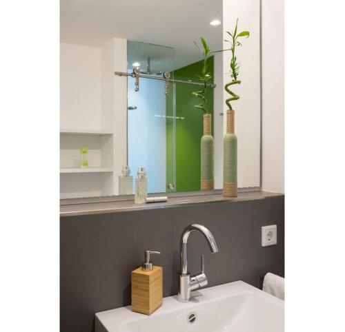 a bathroom with a sink and a mirror at Seven Hotel + Boardinghouse in Herzogenaurach