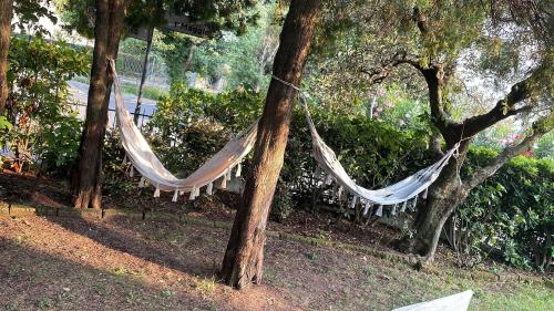 a hammock hanging between two trees in a park at B&B Happy Days Affittacamere in Sirmione
