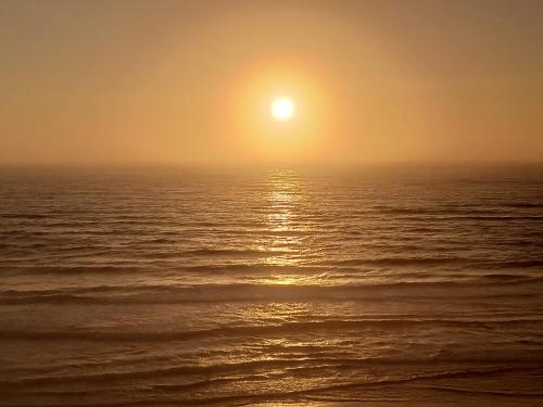 an image of the sun setting over the ocean at Mar & Praia - Apartamento Pedra Ouro in Pedra Do Ouro