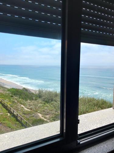 a view of the ocean from a window at Mar & Praia - Apartamento Pedra Ouro in Pedra Do Ouro