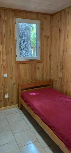 a bedroom with a bed with a window and a red blanket at Freisquéro in Bandol