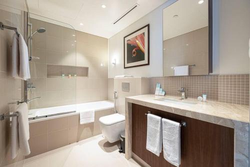 a bathroom with a toilet and a sink and a tub at Cozy 1Bed Connected to DubaiMall BurjKhalifa 5min in Dubai