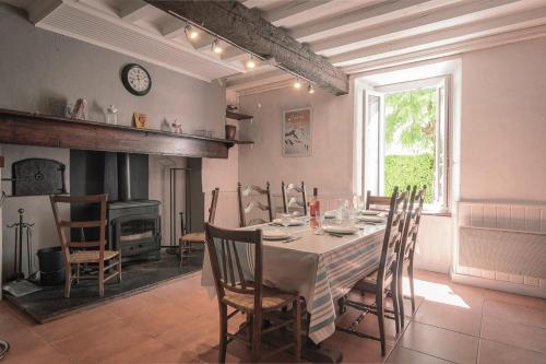 Boutx的住宿－Pyrénées Boutx - Grand Gîte de caractère，用餐室配有桌椅和壁炉
