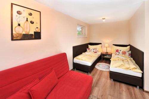 a living room with two beds and a red couch at APLEND Villas Tatry Holiday in Veľký Slavkov